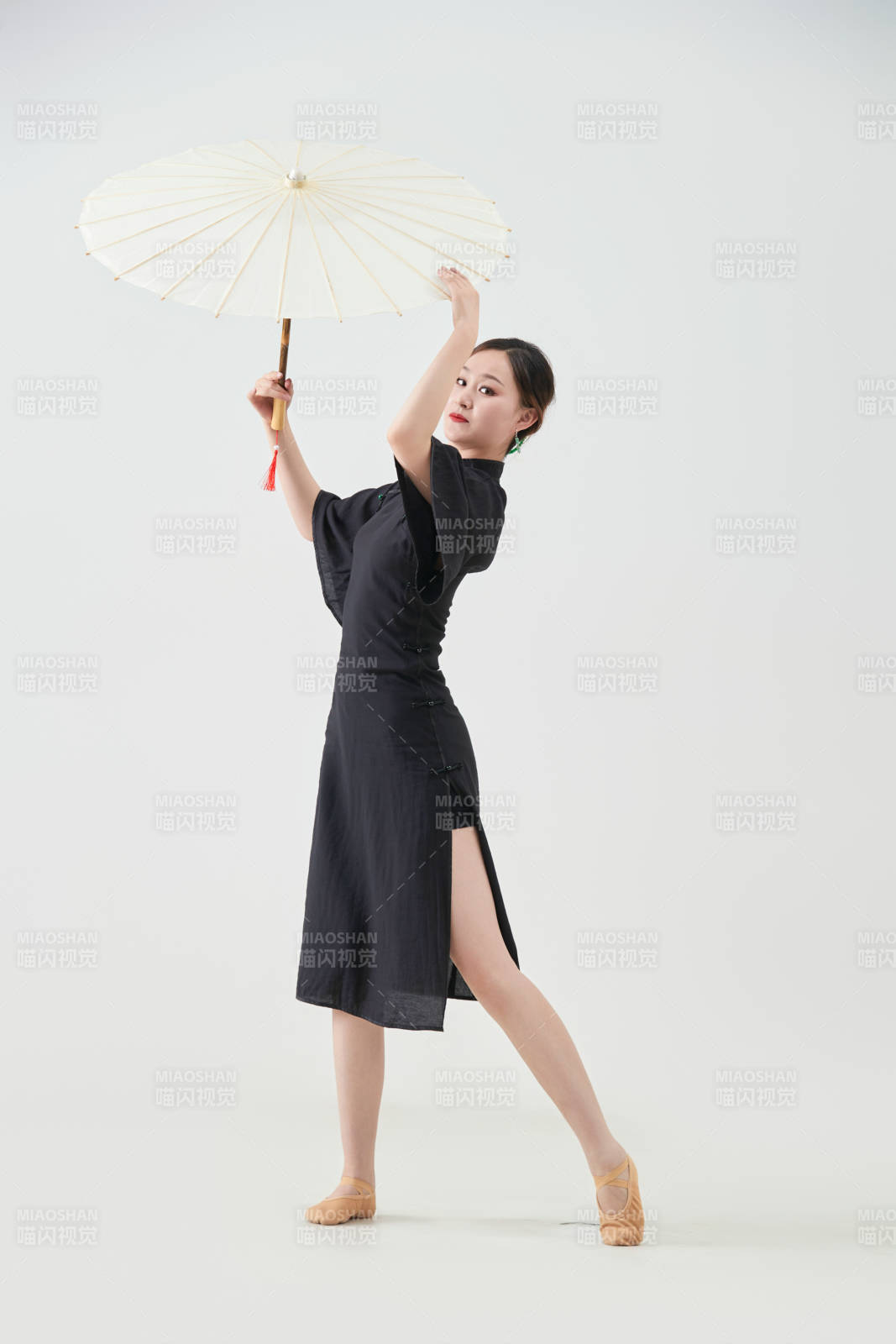 穿中式旗袍手拿油纸伞翩翩舞蹈的亚洲少女舞者