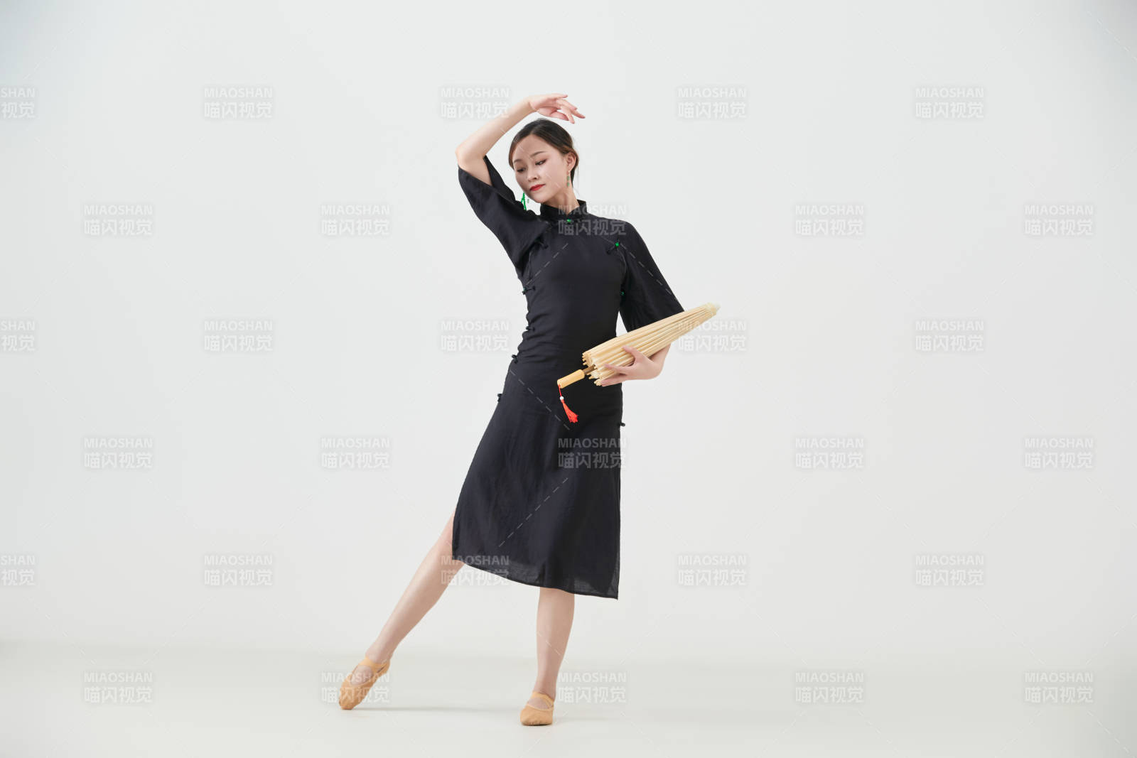 穿中式旗袍手拿油紙傘翩翩舞蹈的亞洲少女舞者