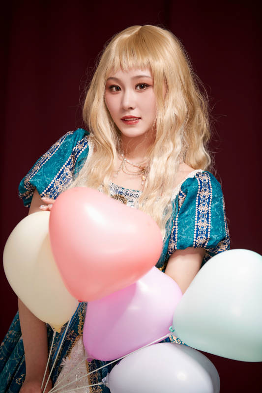 红色背景下穿着欧式宫廷晚装庆祝生日的少女