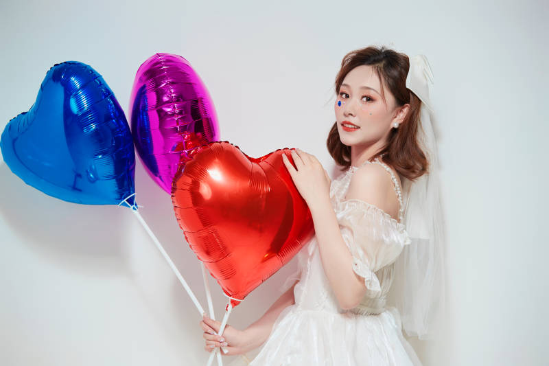 穿着公主裙手拿气球庆祝生日的亚洲女性