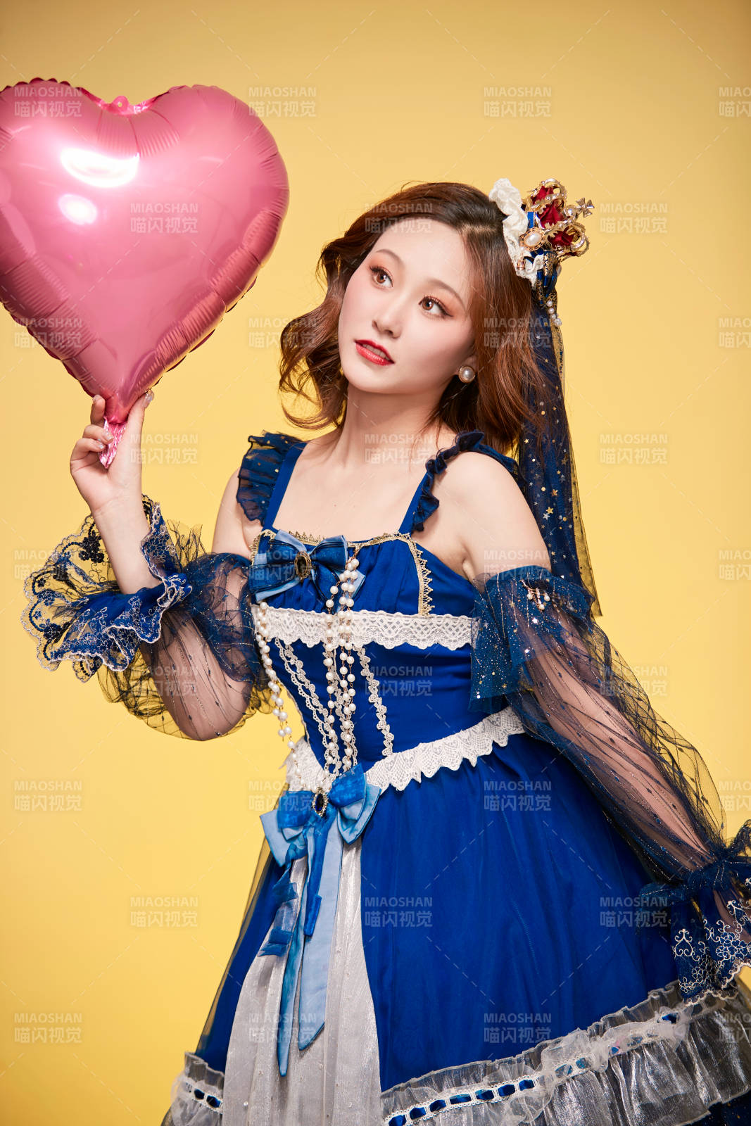 黃色背景下穿著歐式宮廷晚裝慶祝生日的少女