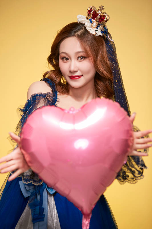 黄色背景下穿着欧式宫廷晚装庆祝生日的少女