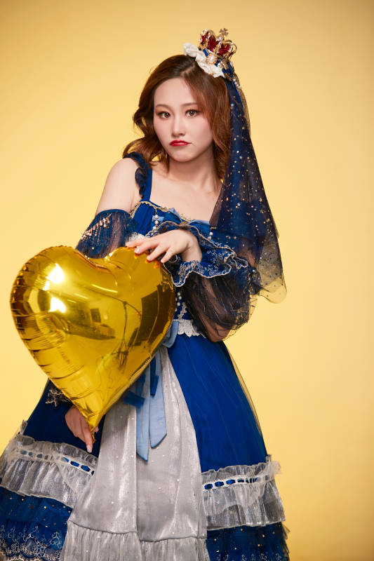 黄色背景下穿着欧式宫廷晚装庆祝生日的少女