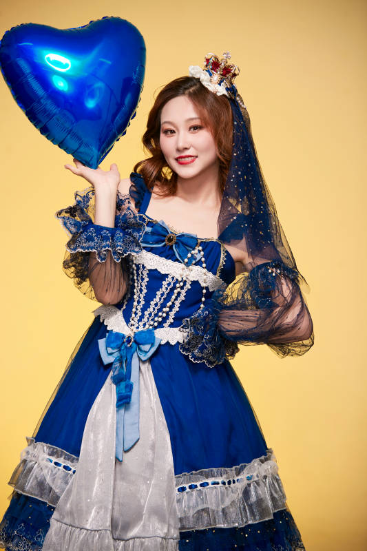 黄色背景下穿着欧式宫廷晚装庆祝生日的少女