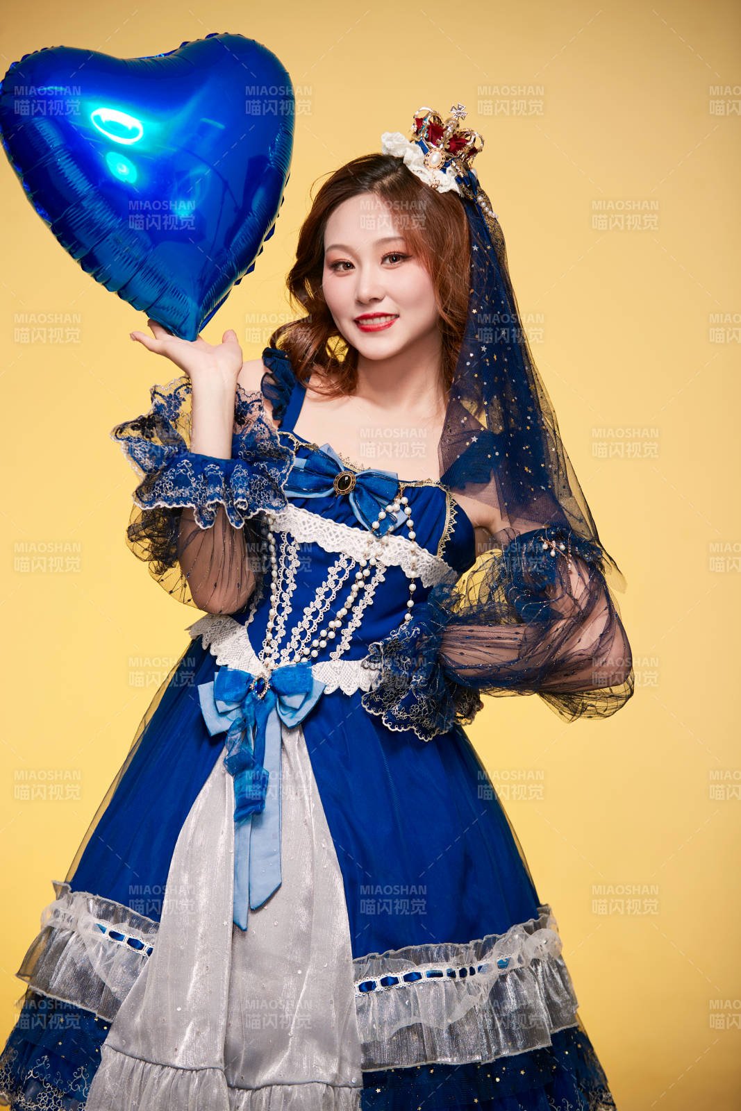 黄色背景下穿着欧式宫廷晚装庆祝生日的少女