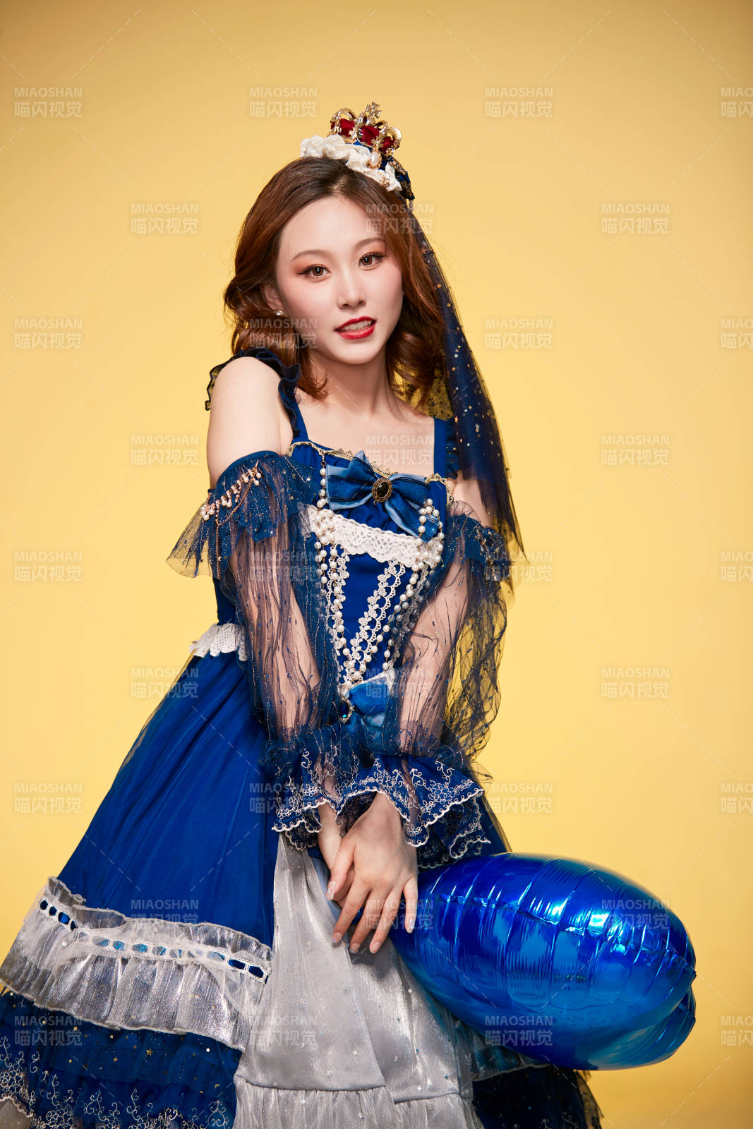 黃色背景下穿著歐式宮廷晚裝慶祝生日的少女