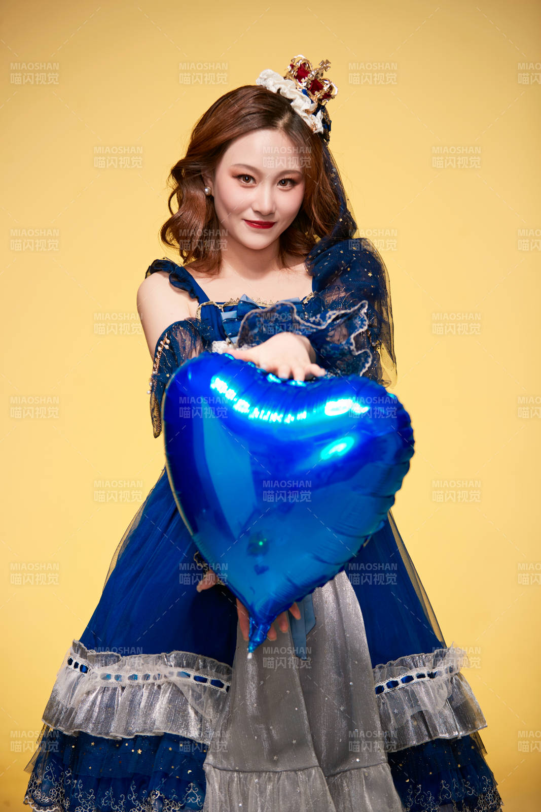 黄色背景下穿着欧式宫廷晚装庆祝生日的少女