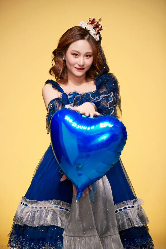 黄色背景下穿着欧式宫廷晚装庆祝生日的少女