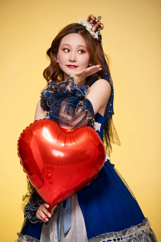 黄色背景下穿着欧式宫廷晚装庆祝生日的少女