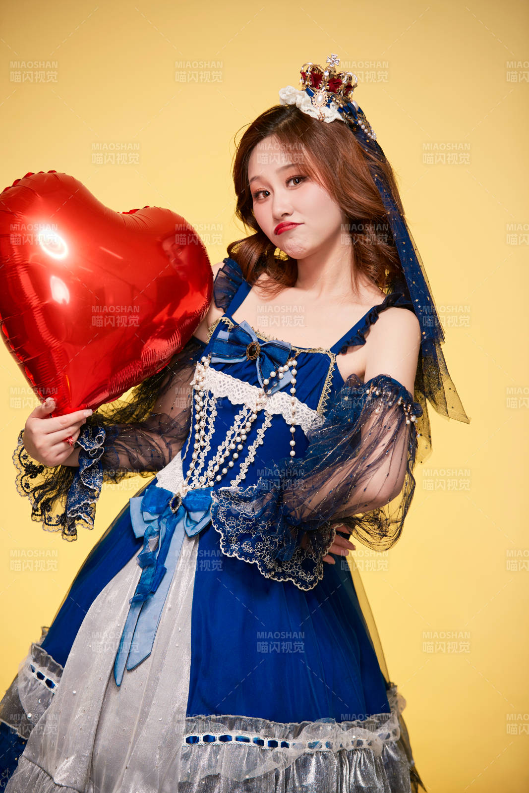 黄色背景下穿着欧式宫廷晚装庆祝生日的少女