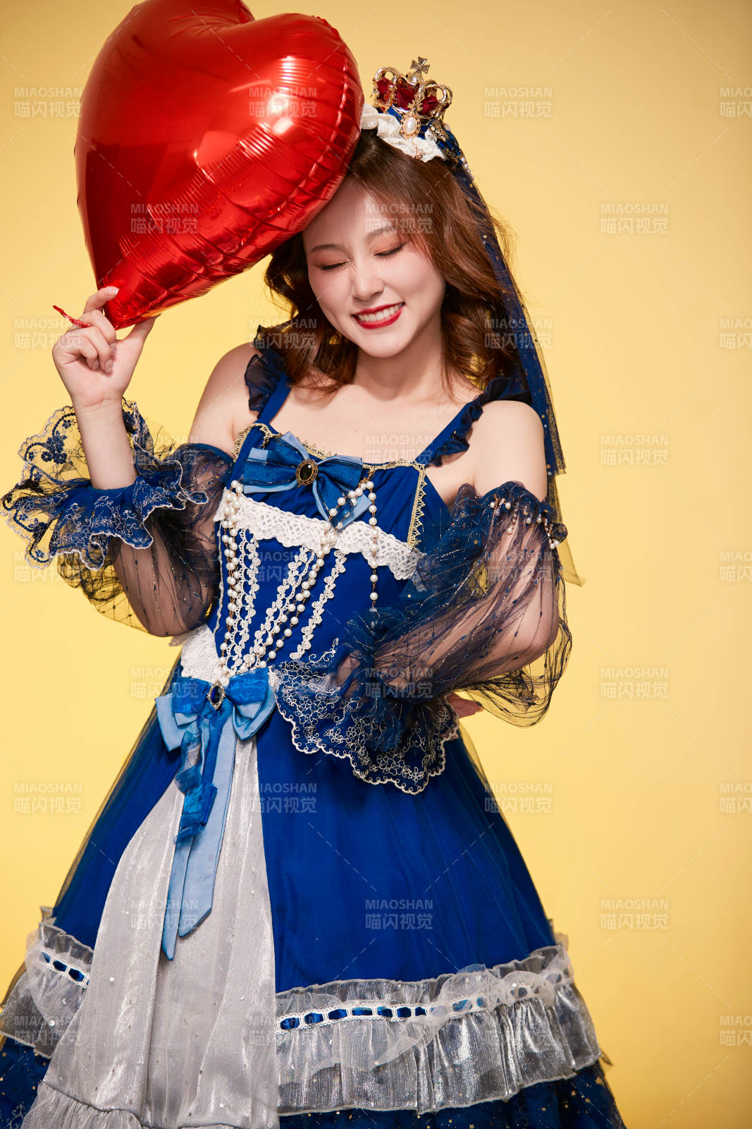 黃色背景下穿著歐式宮廷晚裝慶祝生日的少女