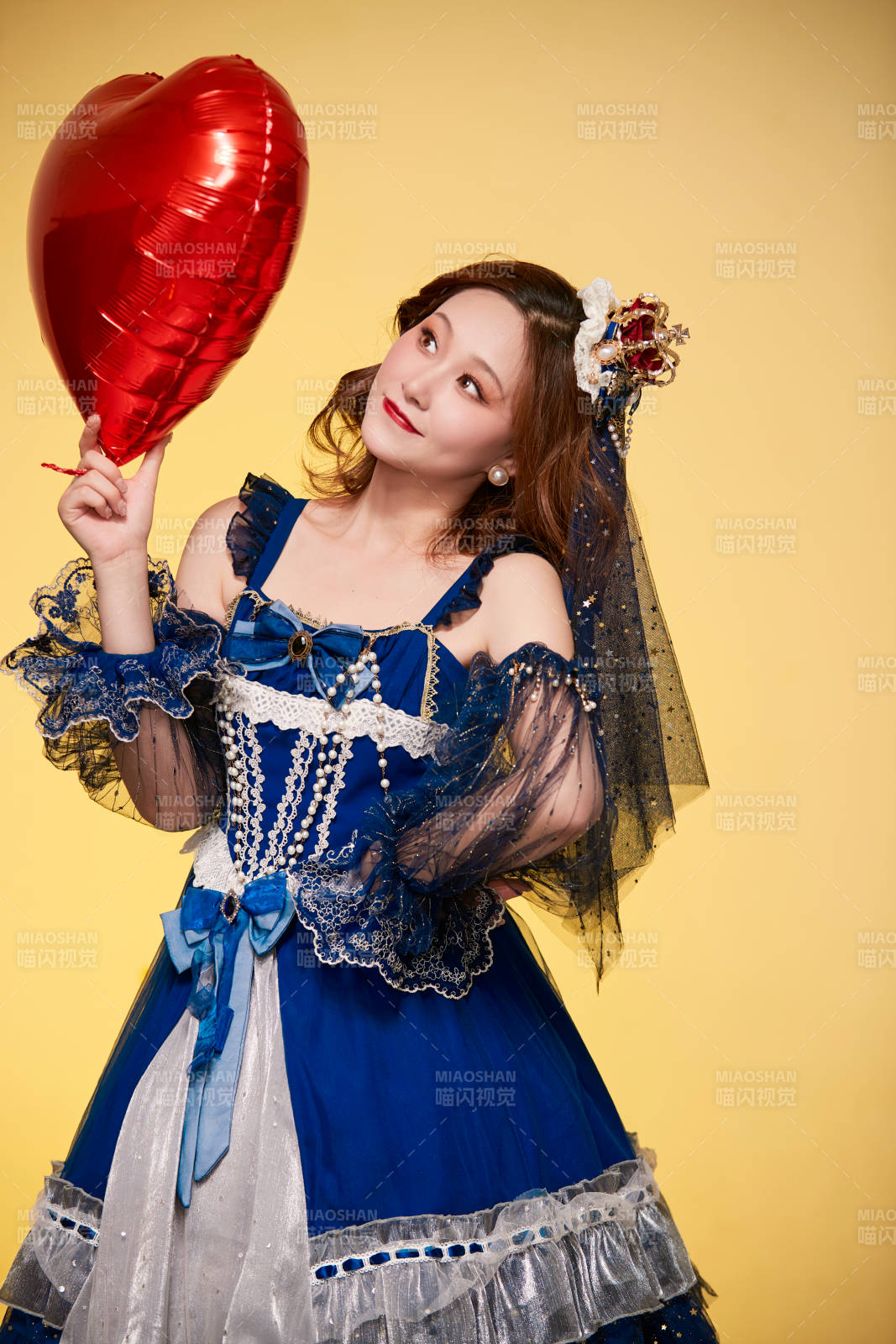 黃色背景下穿著歐式宮廷晚裝慶祝生日的少女