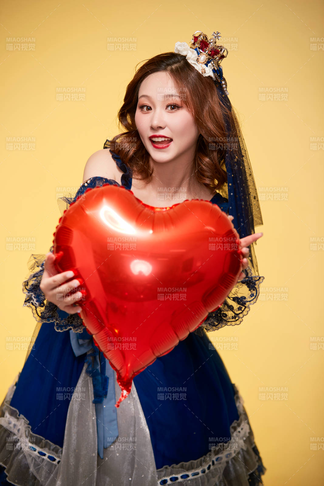 黃色背景下穿著歐式宮廷晚裝慶祝生日的少女