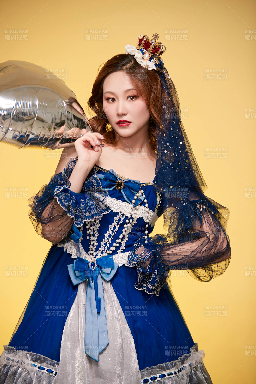 黃色背景下穿著歐式宮廷晚裝慶祝生日的少女