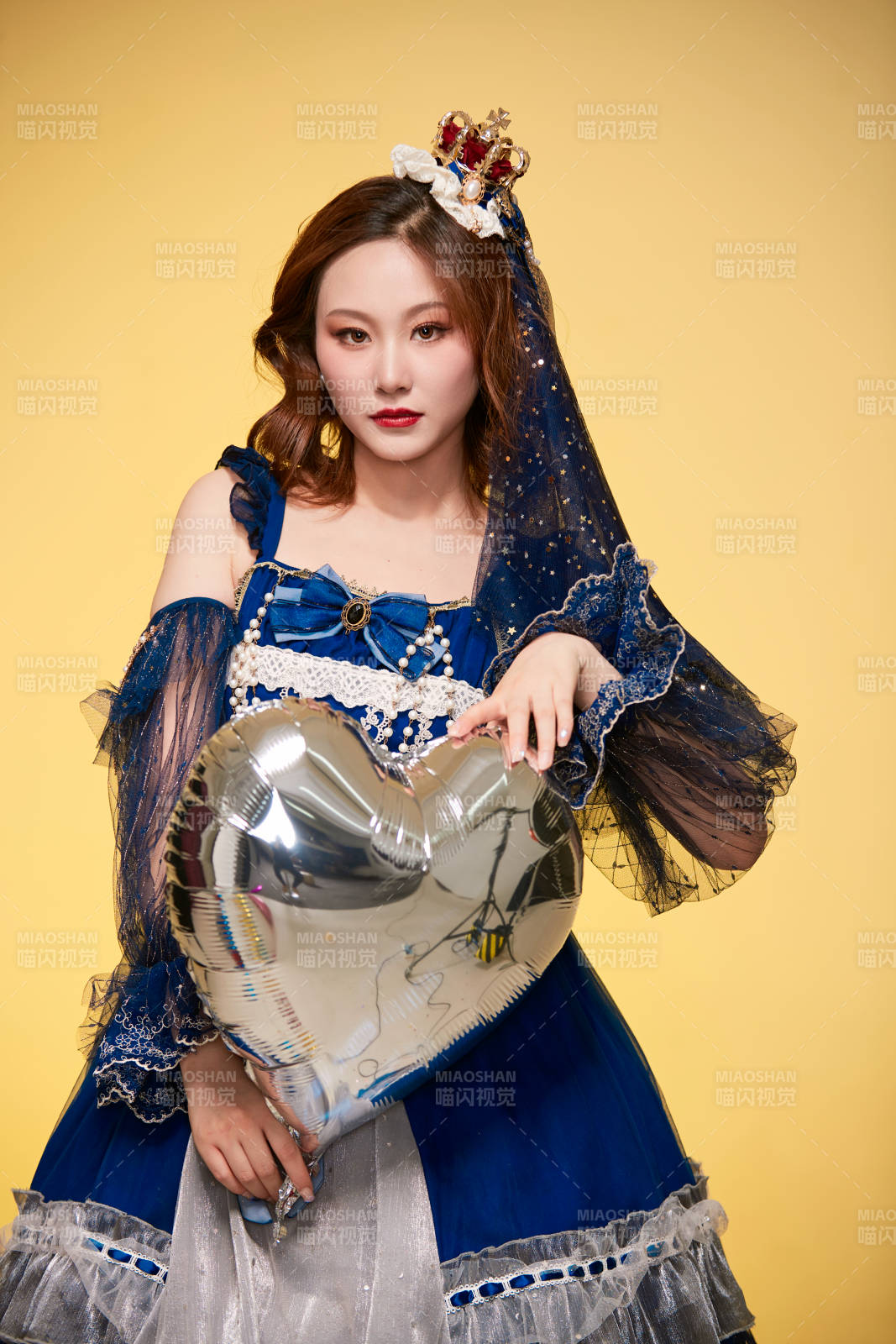 黃色背景下穿著歐式宮廷晚裝慶祝生日的少女