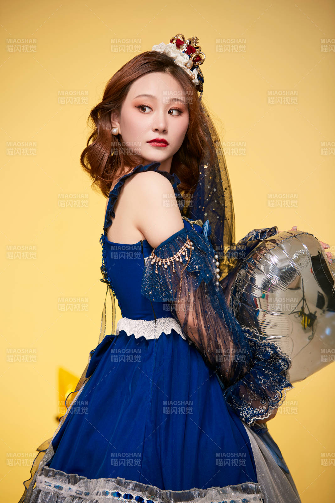 黃色背景下穿著歐式宮廷晚裝慶祝生日的少女