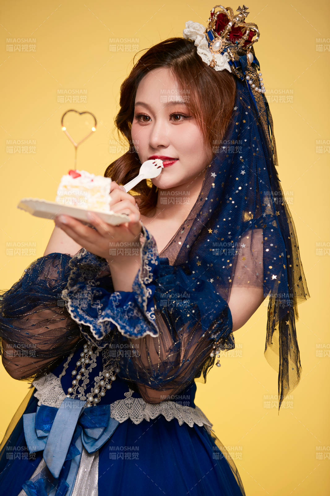 黃色背景下穿著歐式宮廷晚裝慶祝生日的少女