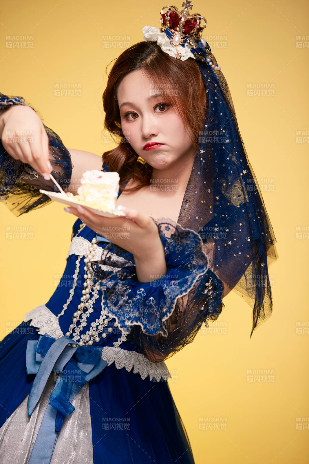 黃色背景下穿著歐式宮廷晚裝慶祝生日的少女