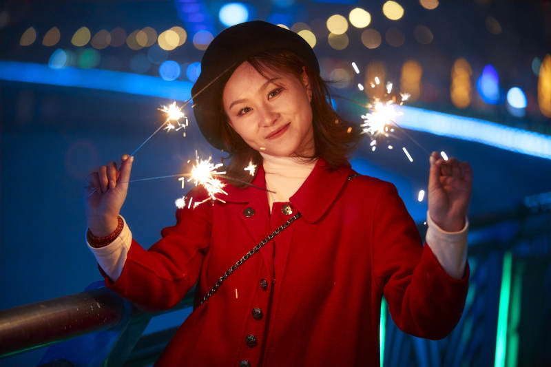 夜晚燃放仙女棒的可爱亚洲少女