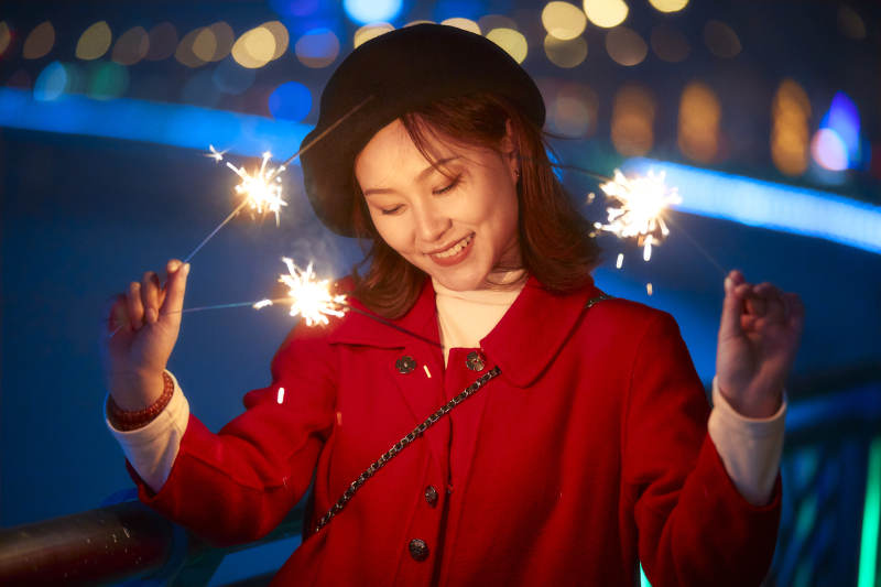 夜晚燃放仙女棒的可爱亚洲少女