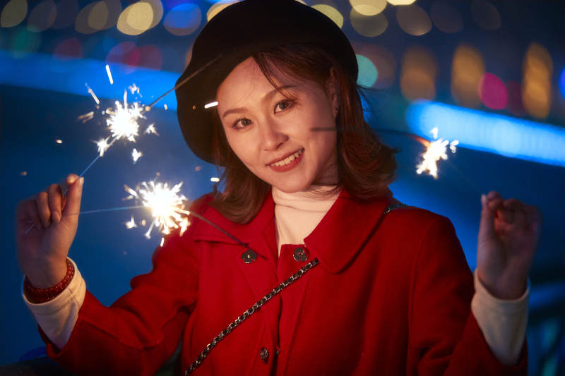 夜晚燃放仙女棒的可爱亚洲少女