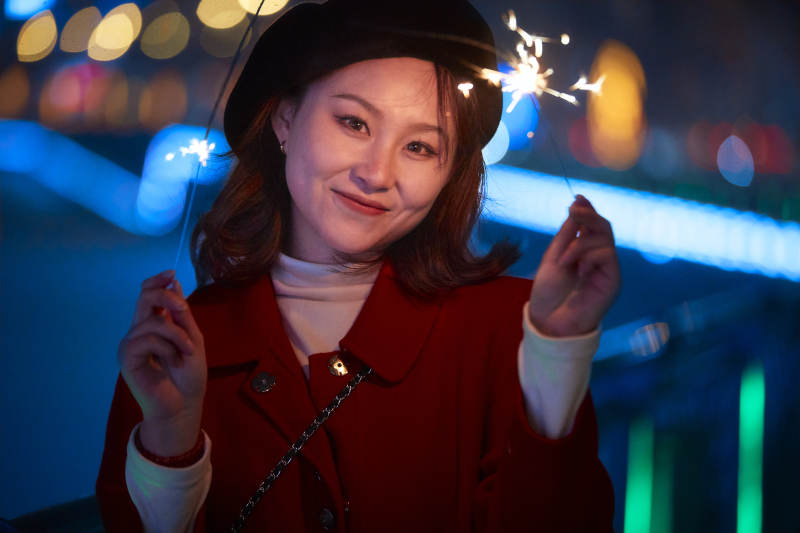 夜晚燃放仙女棒的可爱亚洲少女