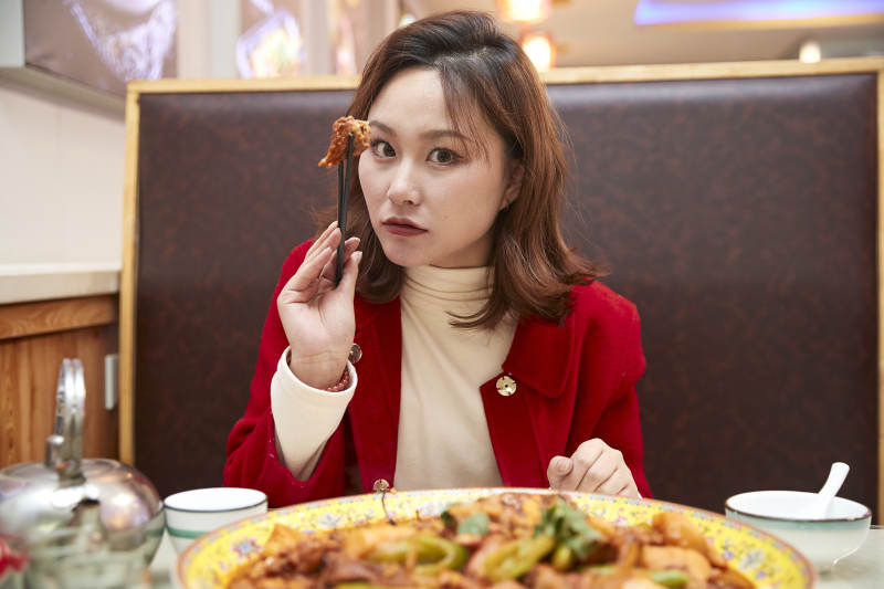 在餐厅吃美味新疆大盘鸡的亚洲少女