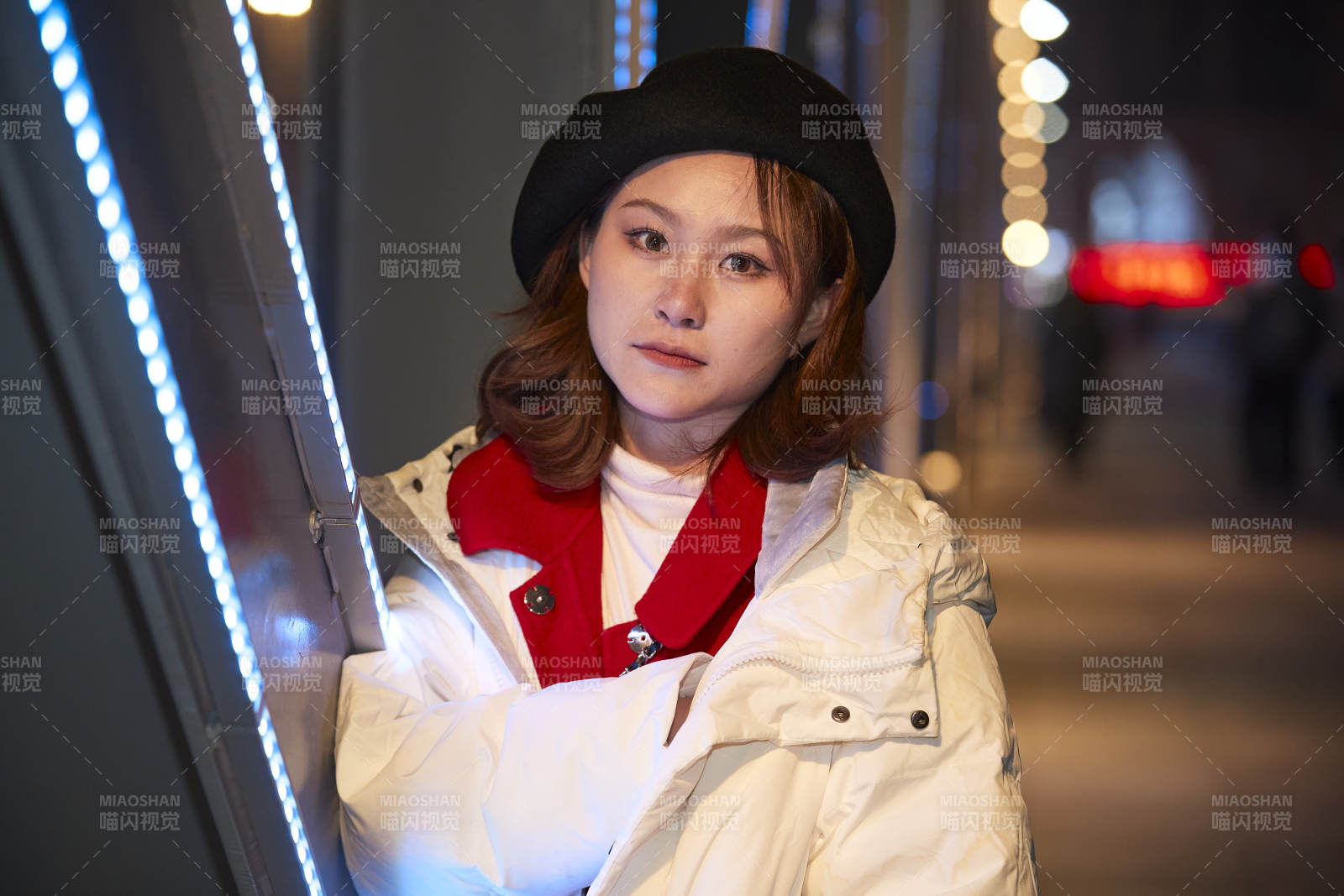 夜晚在繁華燈火的街頭拍照的亞洲少女