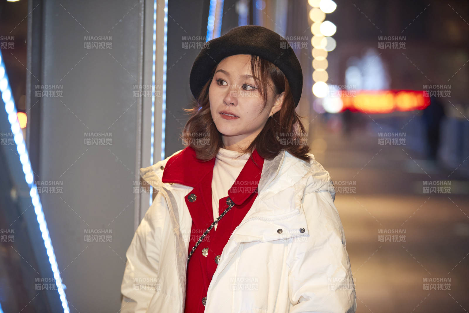 夜晚在繁华灯火的街头拍照的亚洲少女