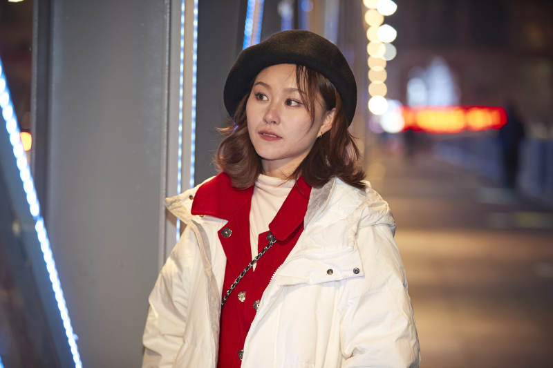 夜晚在繁华灯火的街头拍照的亚洲少女