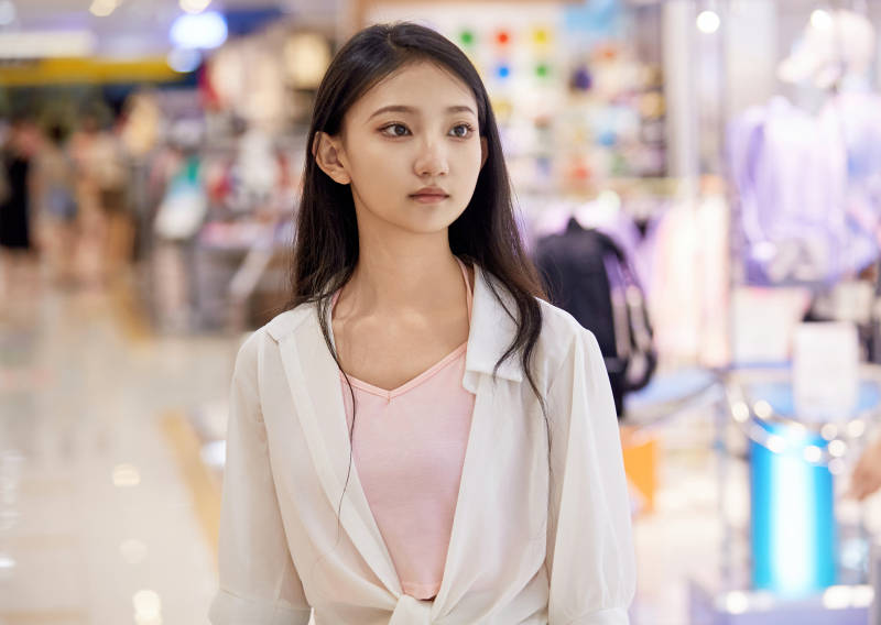 假日悠闲逛商场服装区的中国少女