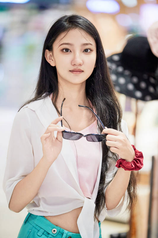 假日悠闲逛商场服装区的中国少女