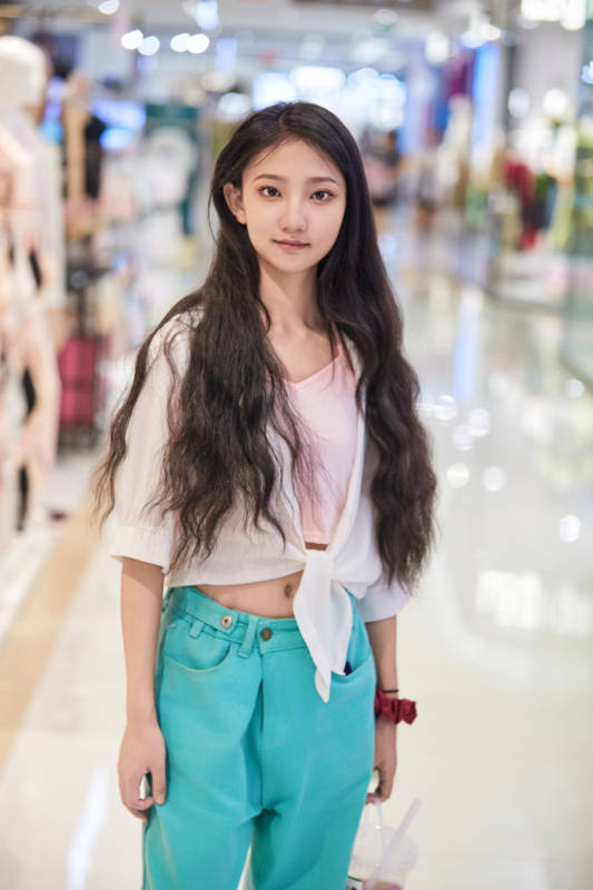 假日悠闲逛商场服装区的中国少女