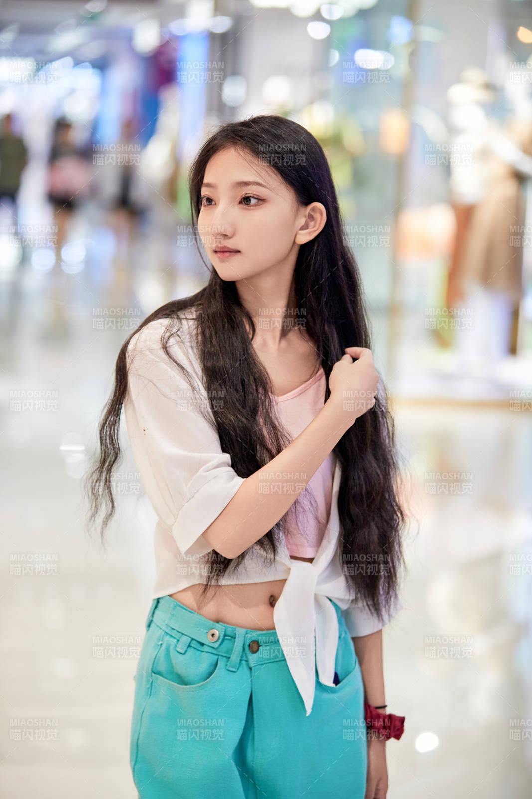 假日悠閑逛商場(chǎng)服裝區(qū)的中國(guó)少女