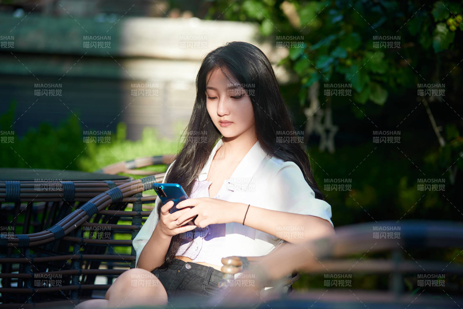 夕阳下在庭院休息拍照的亚洲少女图片