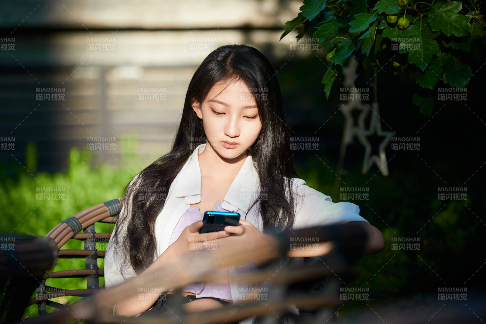 夕阳下在庭院休息拍照的亚洲少女图片