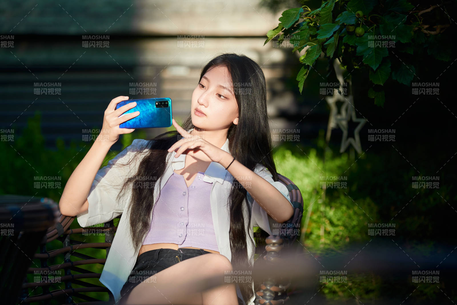 夕陽下在庭院休息拍照的亞洲少女