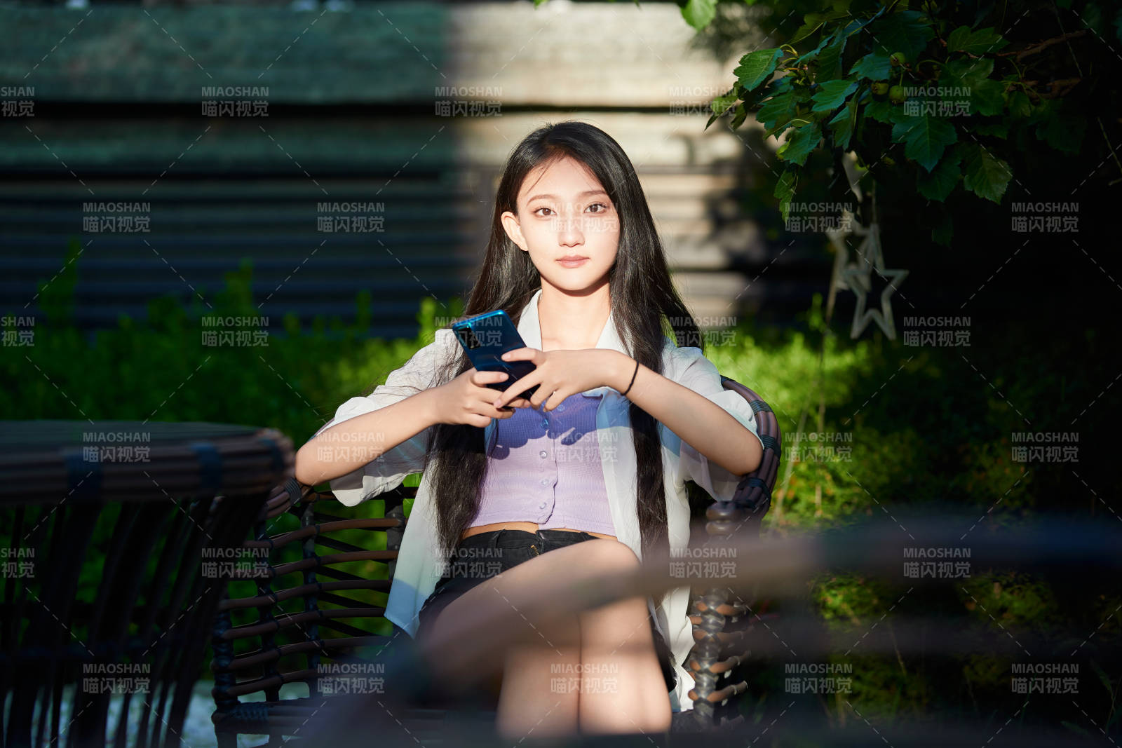 夕阳下在庭院休息拍照的亚洲少女