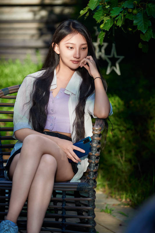 夕阳下在庭院休息拍照的亚洲少女