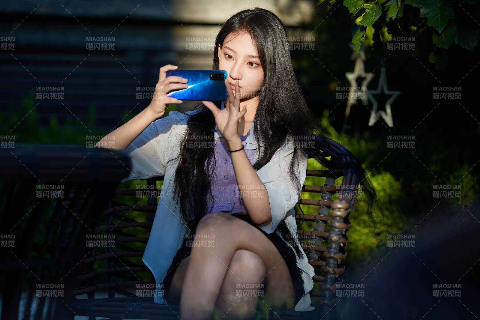 夕陽下在庭院休息拍照的亞洲少女