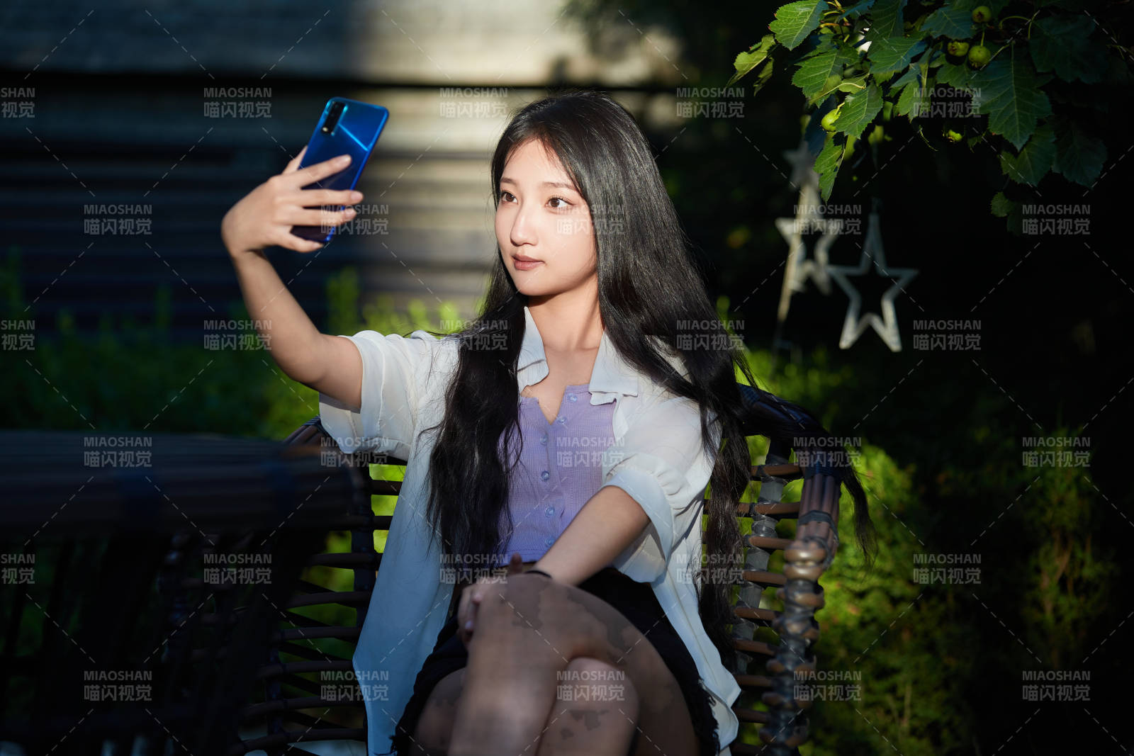 夕陽下在庭院休息拍照的亞洲少女