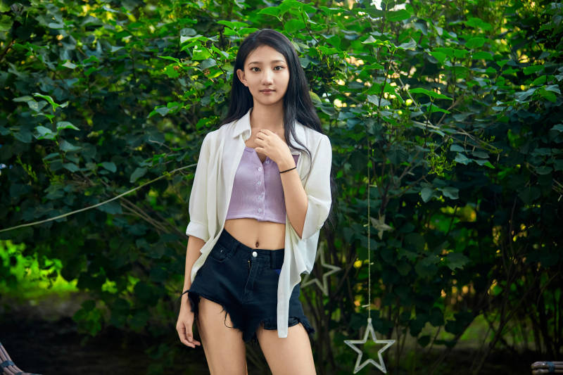 夕阳下在庭院休息拍照的亚洲少女