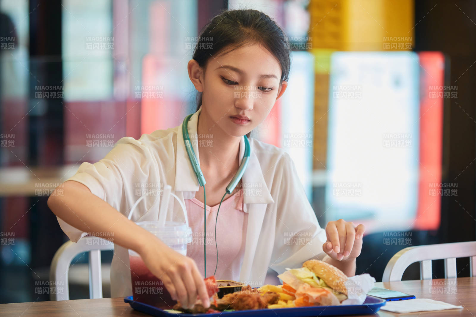 在商場快餐廳大吃特吃的中國可愛少女人像