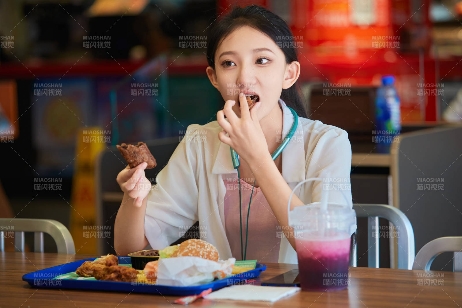 在商場快餐廳大吃特吃的中國可愛少女人像