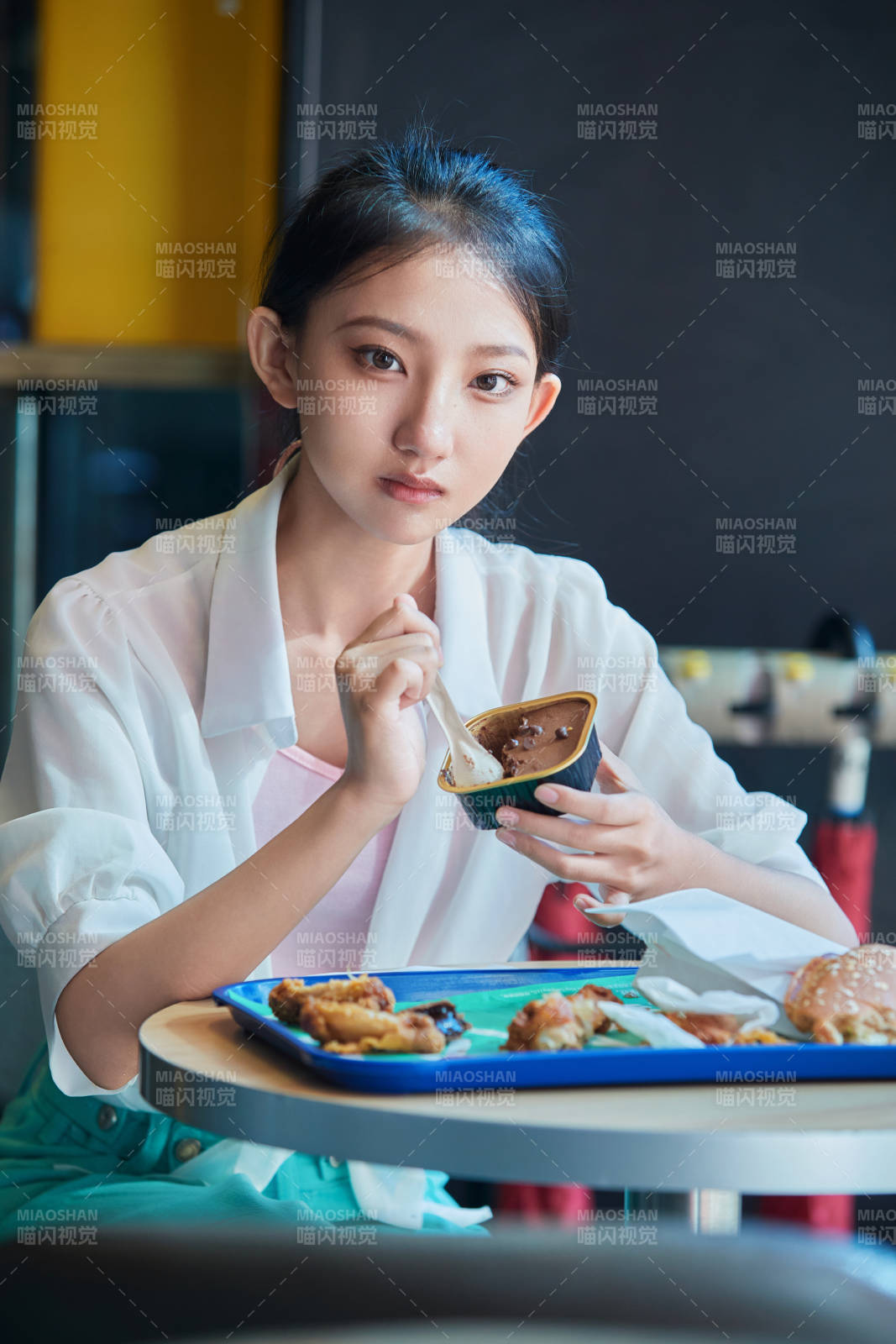 在商場快餐廳大吃特吃的中國可愛少女人像