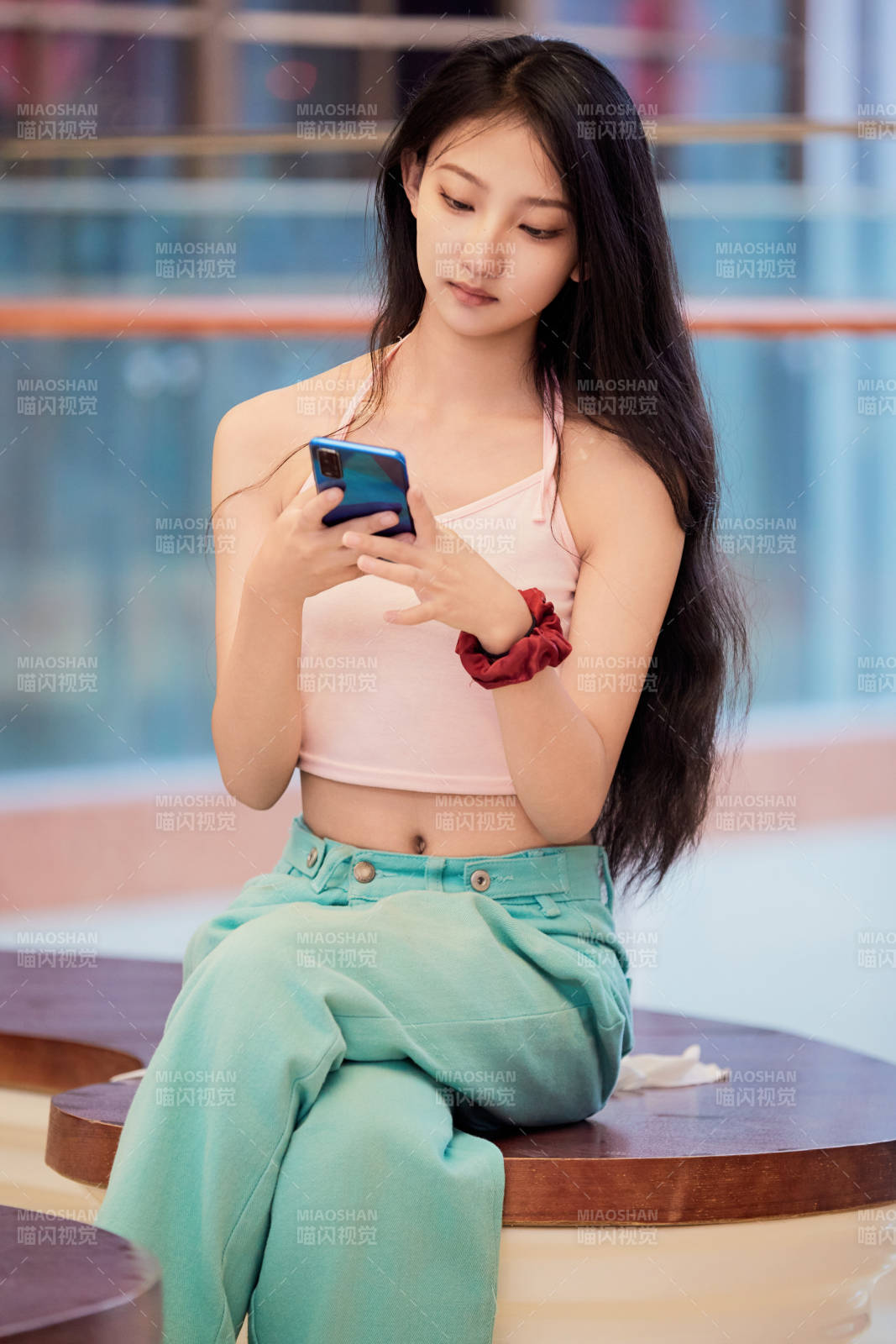 假日在商場(chǎng)休息區(qū)用手機(jī)自拍的中國(guó)少女