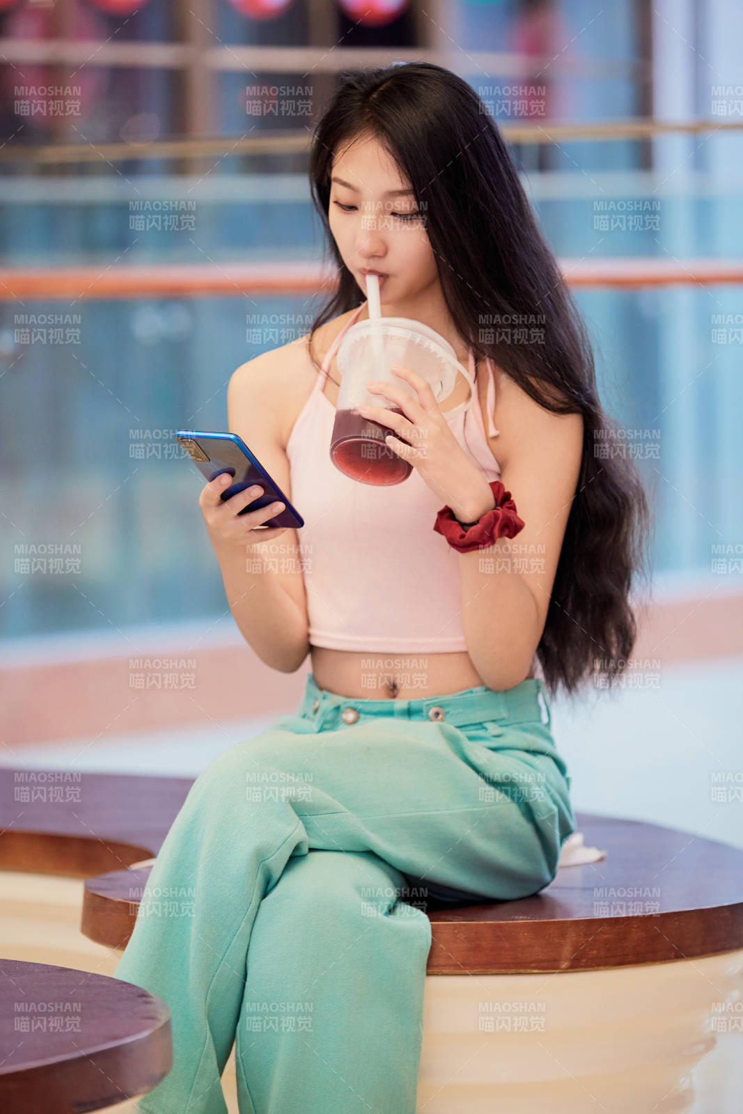 假日在商場休息區用手機自拍的中國少女