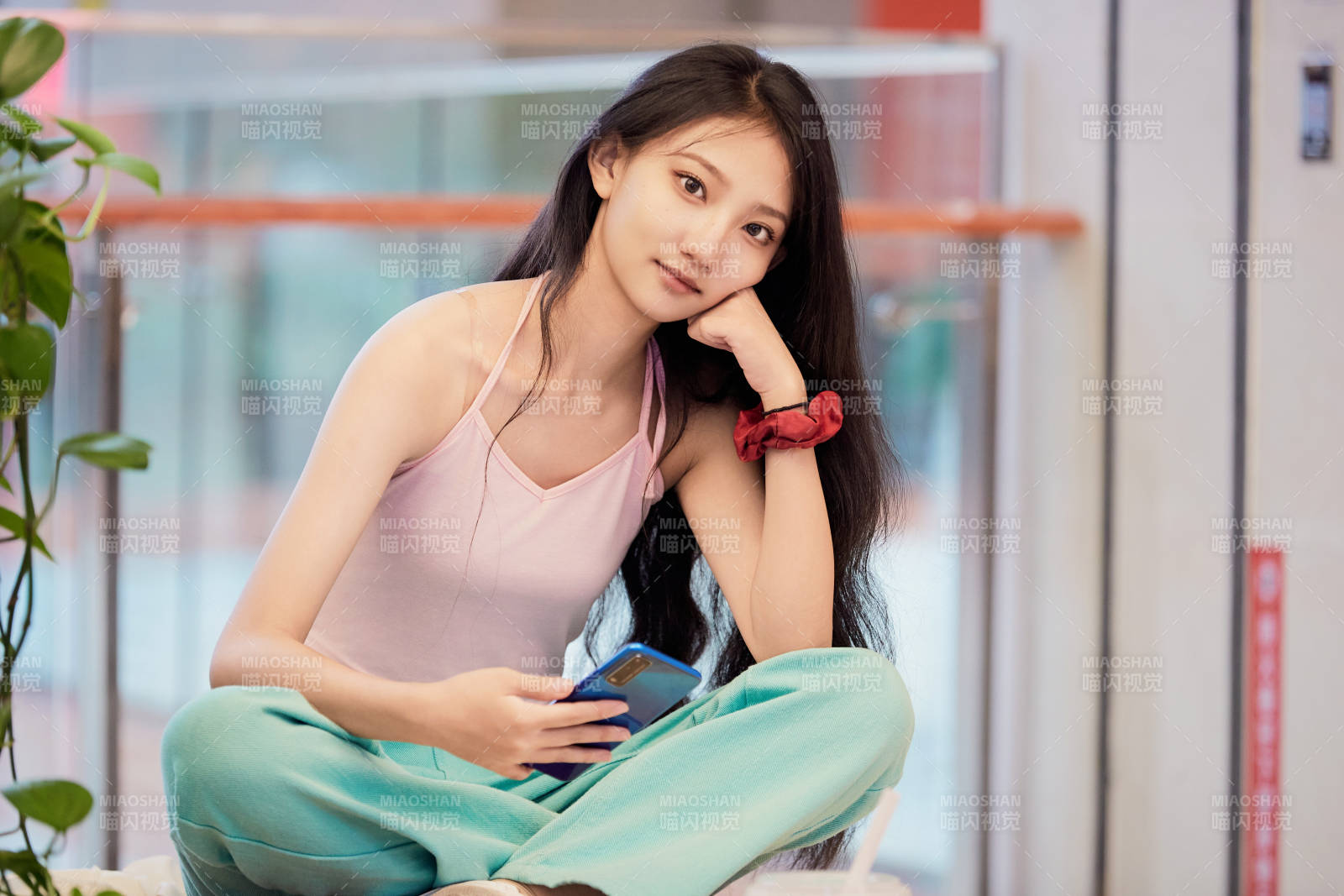 假日在商场休息区用手机自拍的中国少女
