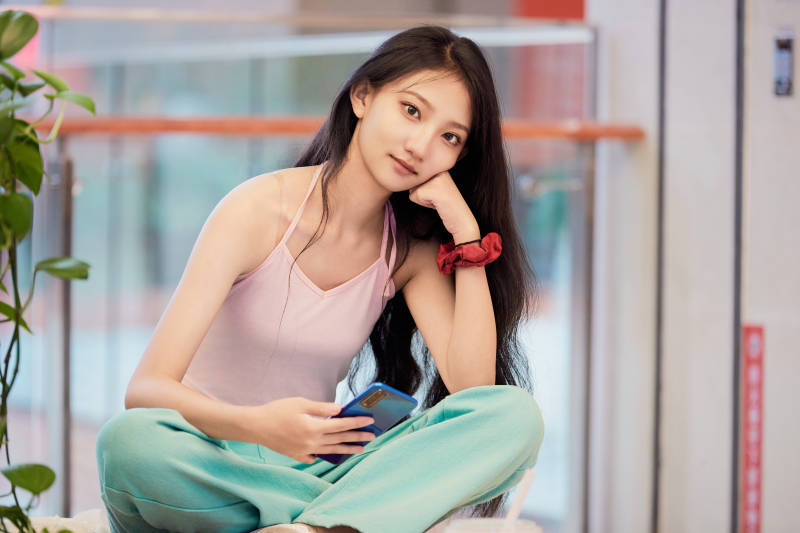 假日在商场休息区用手机自拍的中国少女