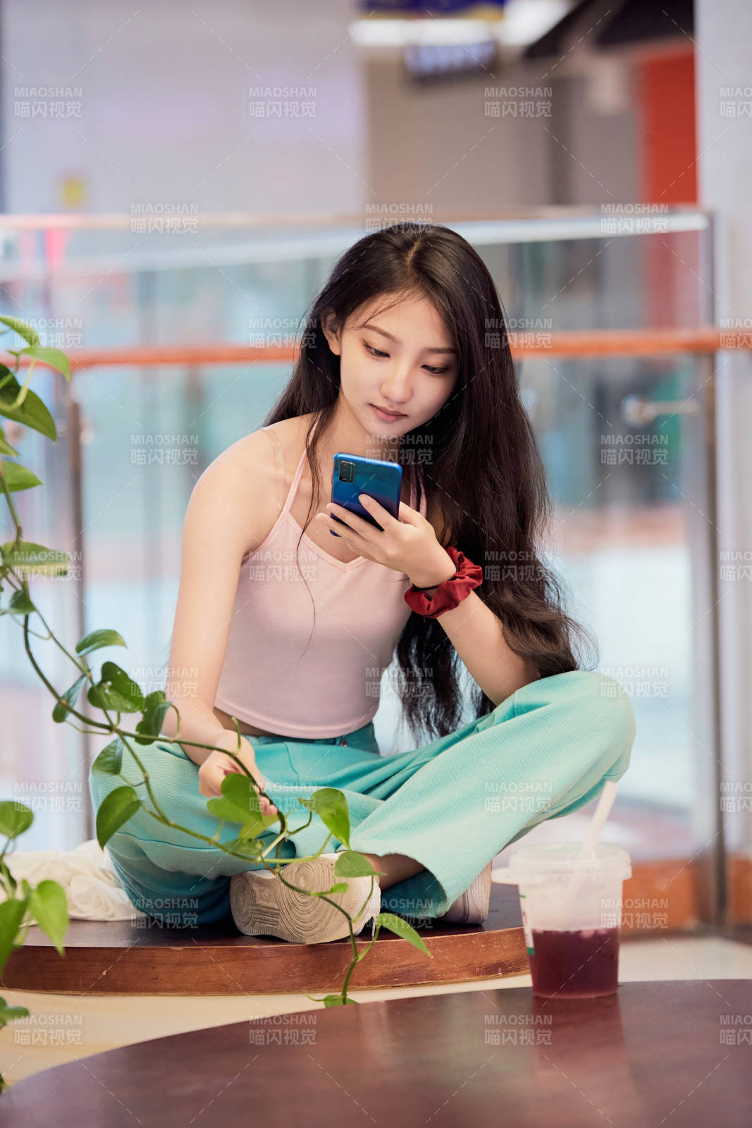 假日在商場休息區用手機自拍的中國少女